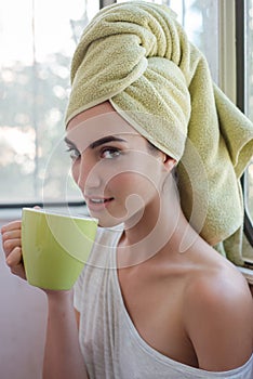 Beautiful young woman with morning cup of hot beverage.