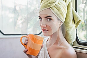 Beautiful young woman with morning cup of hot beverage.