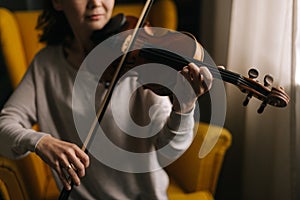 Beautiful young woman musician playing the violin close-up