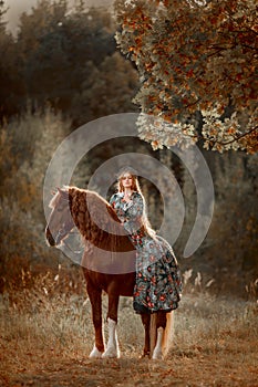 Beautiful young woman in national russian style with red draft horse