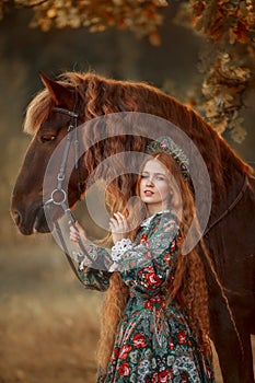 Beautiful young woman in national russian style with red draft horse