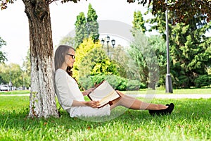 Beautiful young woman with notepad in park