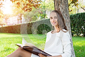 Beautiful young woman with notepad in park