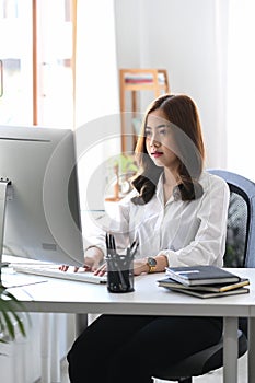 Beautiful young woman office worker working with computer.