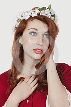 Beautiful young woman in old-fashioned princess costume looking away against gray background