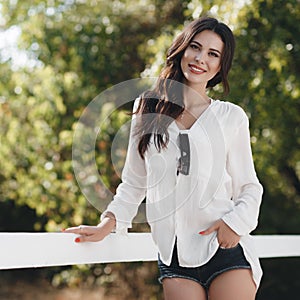 Beautiful young woman outdoors alone in a green summer park