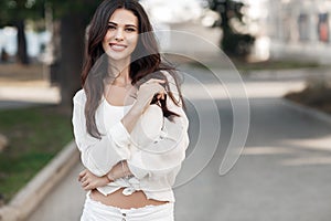 Beautiful young woman outdoors alone in a green summer park