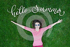 Beautiful Young Woman Outdoors in Green Grass and text Hello Summer. Calligraphy lettering