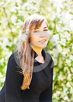 Beautiful young woman over white blossom tree, outdoors spring portrait