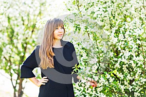 Beautiful young woman over white blossom tree, outdoors spring portrait