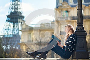 Beautiful young woman in Paris, reading a book