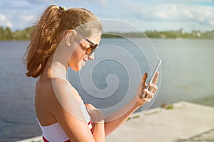 Beautiful young woman in the park using cellphone.