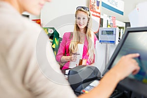 Beautiful young woman paying for her groceries