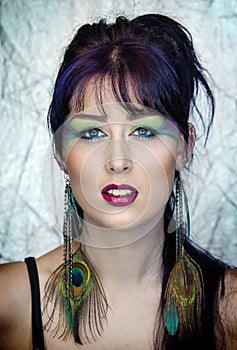 Beautiful young woman in peacock inspired makeup