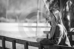 Beautiful young woman pensive in a park with a blank stare. Black and white photo