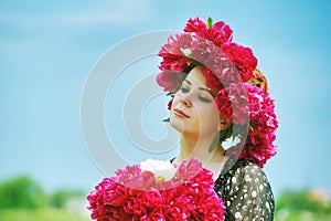 Beautiful young woman with peony flowers