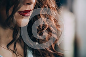 Beautiful young woman with perfect dark curly hair and beautiful make-up with puffy red lips. Close-up. Soft selective focus