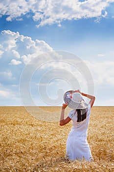 Beautiful young woman on perfect wheat field