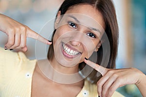 Beautiful young woman with perfect white smile looking at camera at home