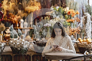 A beautiful young woman with a phone in hand at the decor store