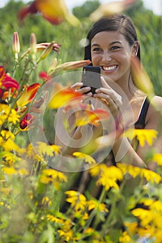 Krásny mladá žena fotografovanie kvety 