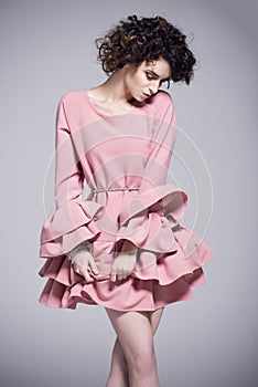 Beautiful young woman in a pink dress with frills