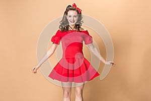 Beautiful young woman with pinup make-up and hairstyle. Studio shot on pastel background