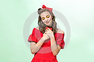 Beautiful young woman with pinup make-up and hairstyle. Studio shot on white background