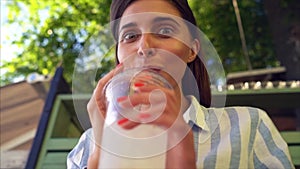 Beautiful young woman with plastic cup of fresh cocktail