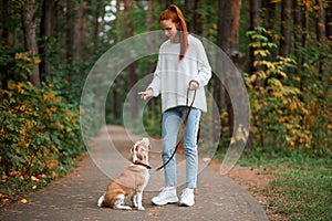Beautiful young woman with playful young dog having fun outdoors