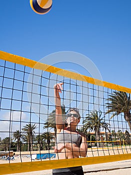 Beautiful young woman playing beachvolleyball