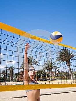 Beautiful young woman playing beachvolleyball