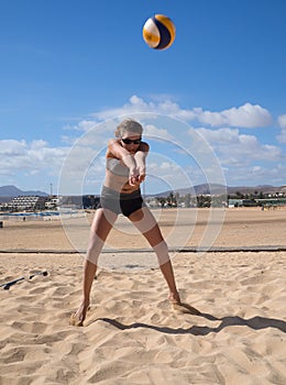 Beautiful young woman playing beachvolleyball