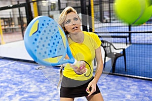 Beautiful young woman playing paddle tennis indoor.