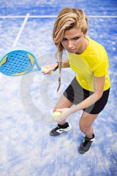 Beautiful young woman playing paddle tennis indoor.