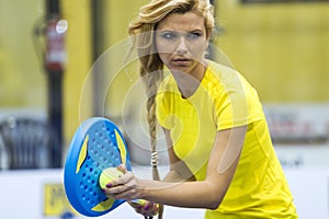 Beautiful young woman playing paddle tennis indoor.