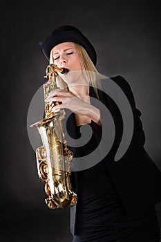 Beautiful young woman playing saxophone