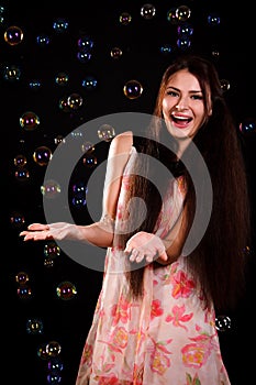 Beautiful young woman playing with soap bubbles