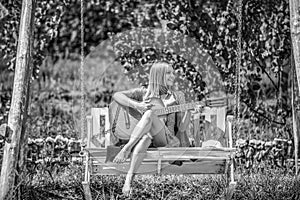 Beautiful young woman plays guitar on park. Happy girl playing guitar outdoor. Young woman enjoy playing guitars. Happy