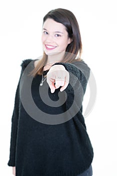 Beautiful young woman pointing at camera standing isolated on white background smiling and looking into the camera