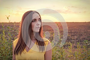 Beautiful young woman portrait against sunset evening field, woman relaxing getaway