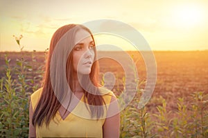Beautiful young woman portrait against sunset evening field, woman relaxing getaway