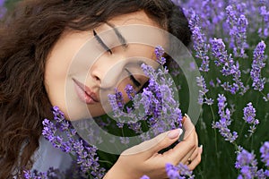 Beautiful young woman portrait on lavender flowers background, face closeup