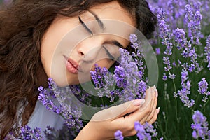 Beautiful young woman portrait on lavender flowers background, face closeup