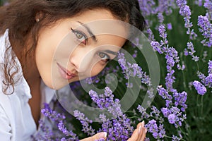 Beautiful young woman portrait on lavender flowers background, face closeup