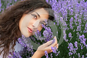 Beautiful young woman portrait on lavender flowers background, face closeup