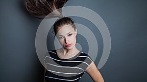 Young pretty woman portrait with ponytail in motion studio shot