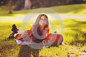 Beautiful young woman portrait with pumpkin in park