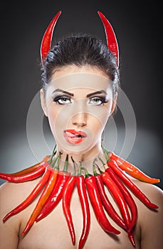 Beautiful young woman portrait with red hot and spicy peppers