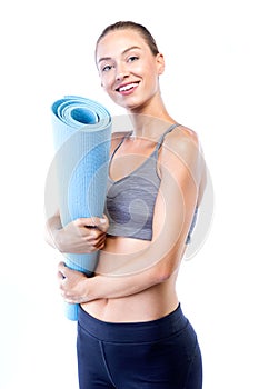 Beautiful young woman posing after doing pilates over white background.